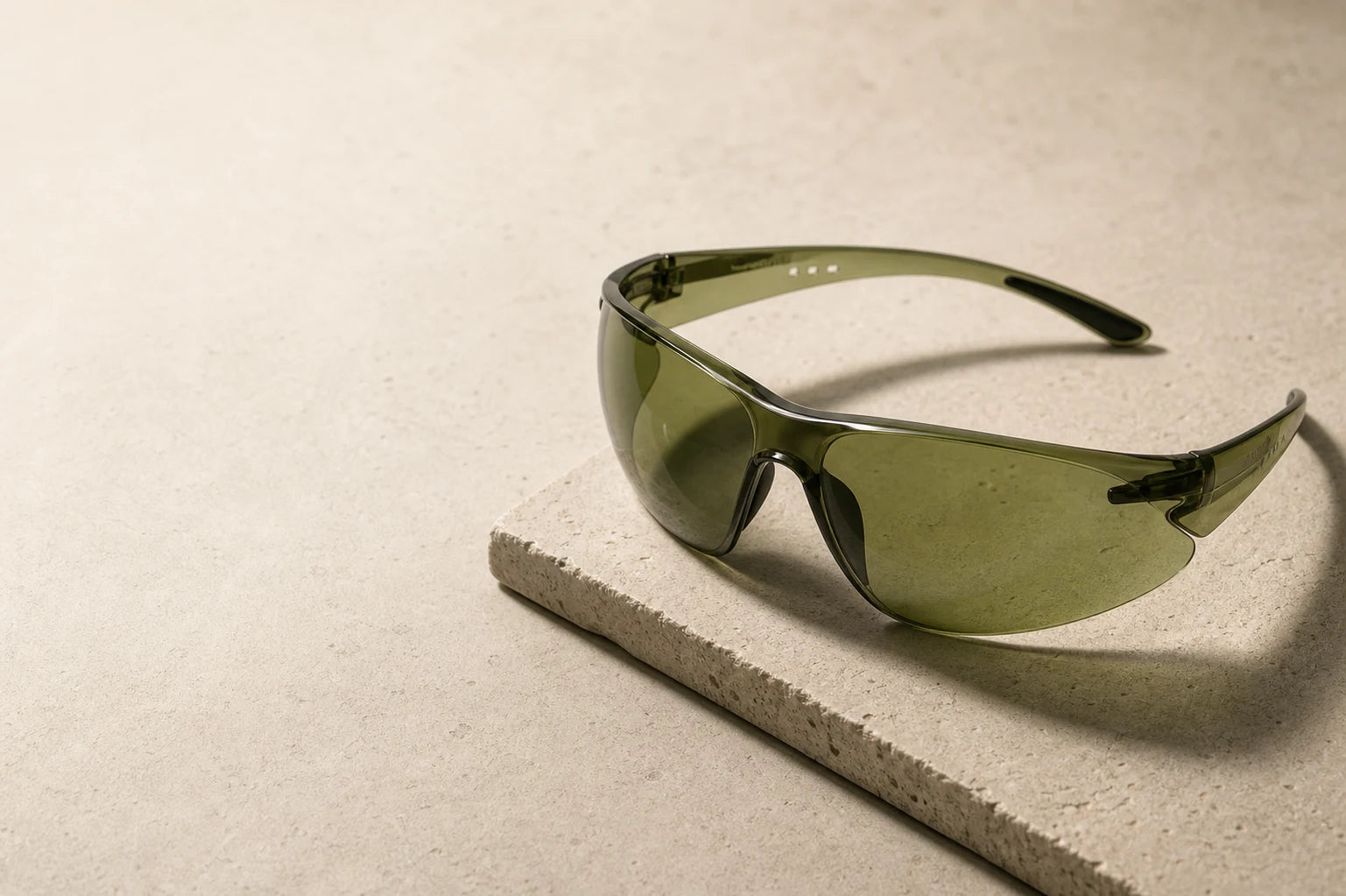 B-Sentinel 430 muted olive eyewear on a warm stone work surface